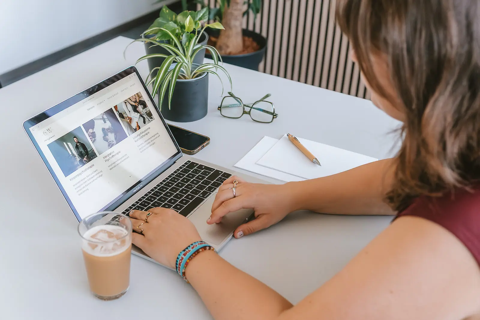 Eine Person arbeitet konzentriert an einem Laptop in einer hellen Umgebung.