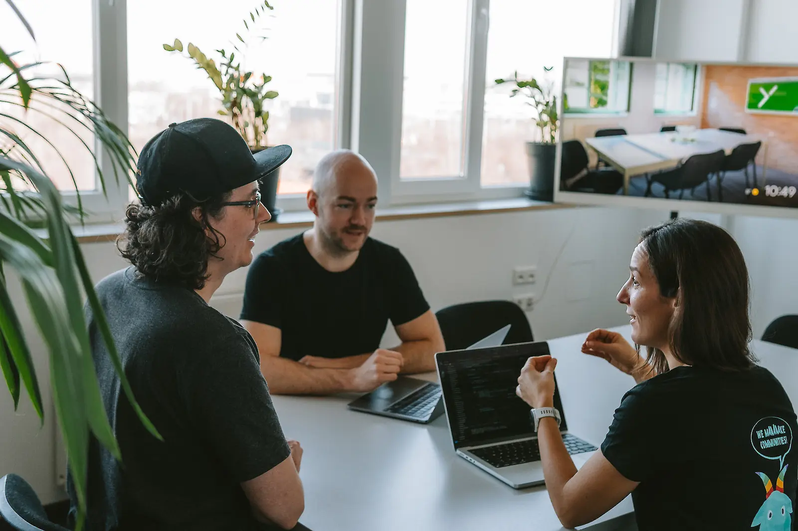 eammitglieder von Youbility sitzen in einem modernen Büro gemeinsam an einem Tisch und führen eine Besprechung durch.